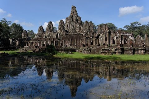 The face towers of Bayon reflected in still water, Angkor Thom
