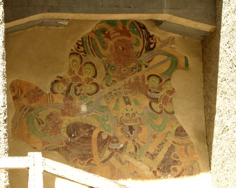 A painted Buddhist figure in a mural at the Mogao Caves in Dunhuang