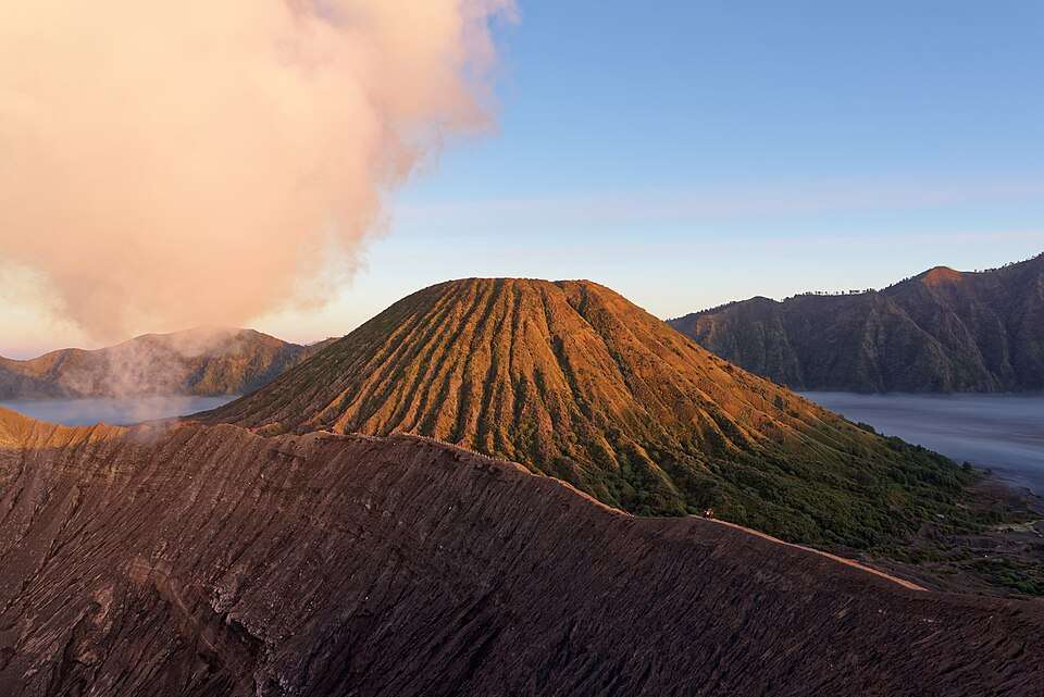 Mount Bromo smoking above a sea of dawn cloud