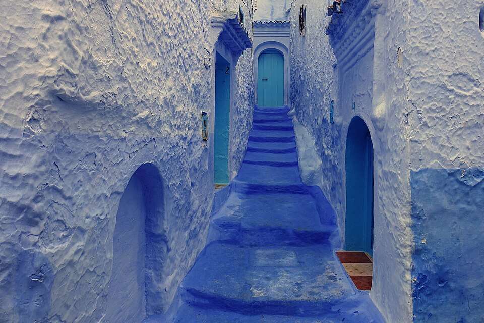 A blue-washed lane climbing through Chefchaouen's medina