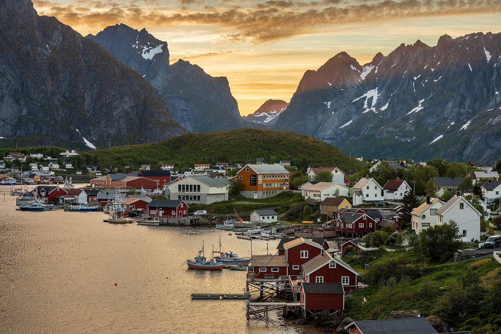 Red rorbu cabins beneath the peaks of Reine in Lofoten