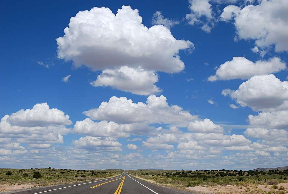 An open stretch of Route 66 running toward desert buttes